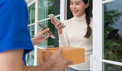 a woman receiving a package from a delivery man